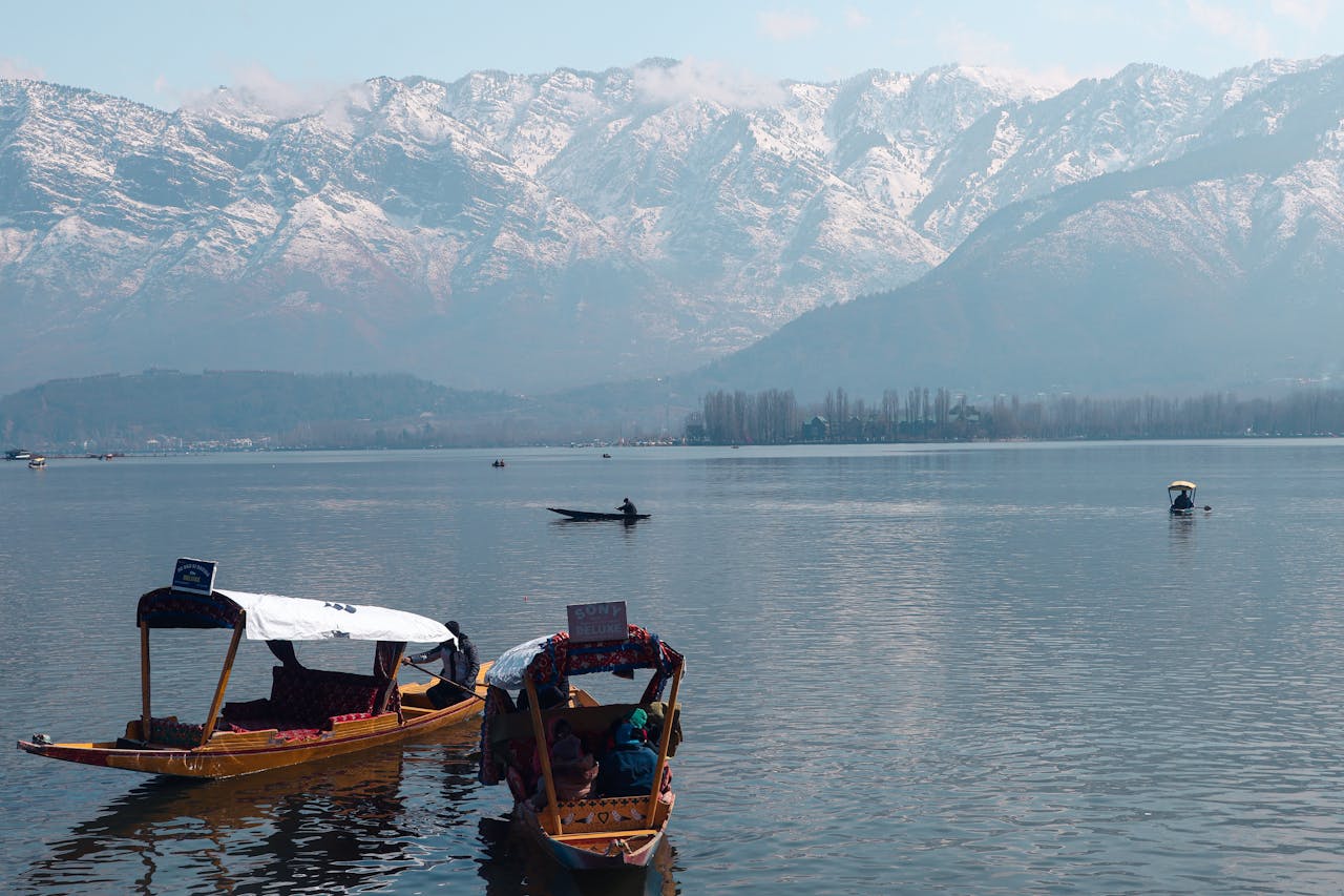 Tranquil boats on Dal Lake with the snowcapped Himalayas in the background in Srinagar.