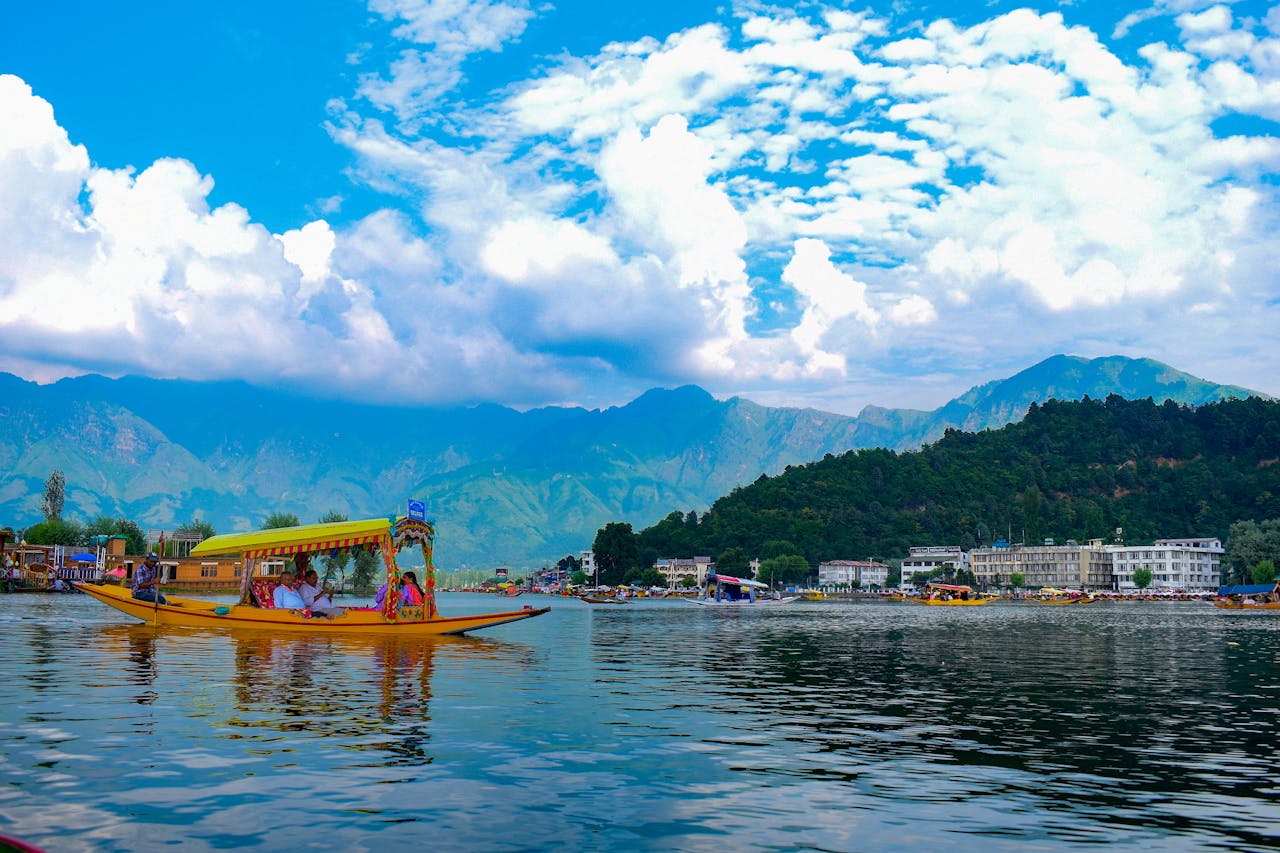 Colorful shikara boat on Dal Lake with stunning Himalayan backdrop in Kashmir, India.