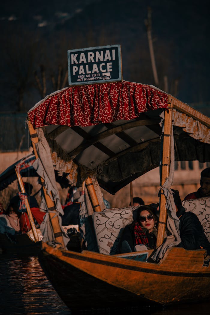 People enjoy a relaxing ride on a decorative wooden boat near Karnai Palace.